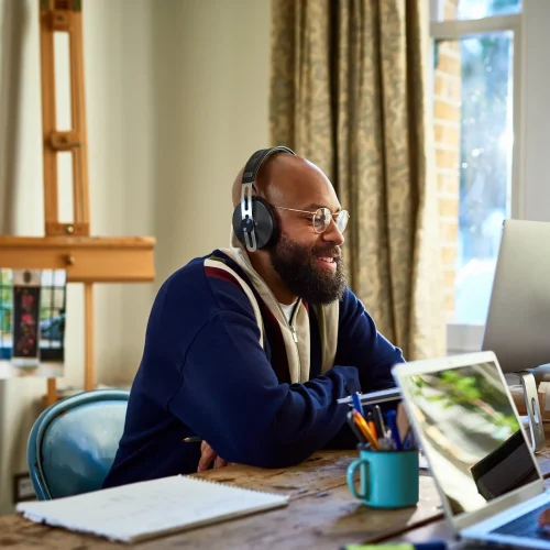 Happy-man-working-from-home-next-to-someone-slightly-off-camera-how-to-get-a-remote-job
